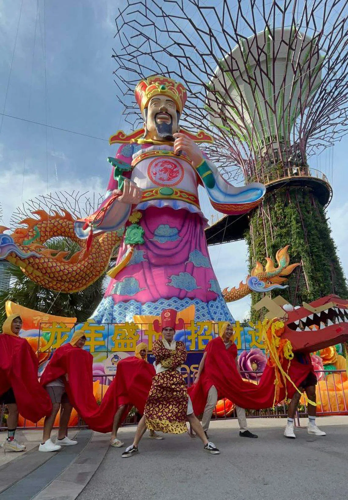 小分队舞龙来到滨海湾花园与财神爷合照。（受访者提供）