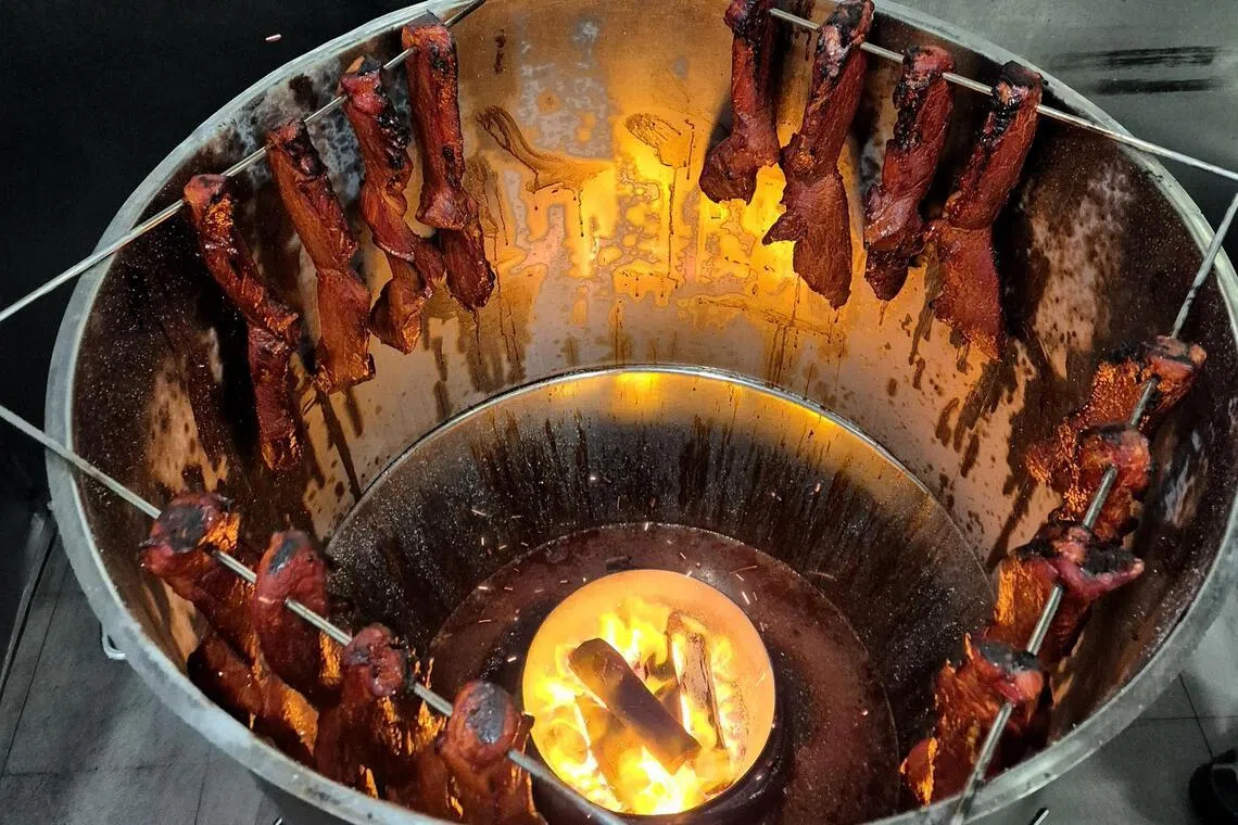 丹戎禺包点坚持以炭火烧烤，烧出琥珀般焦糖光泽的美味叉烧。（陈爱薇摄）