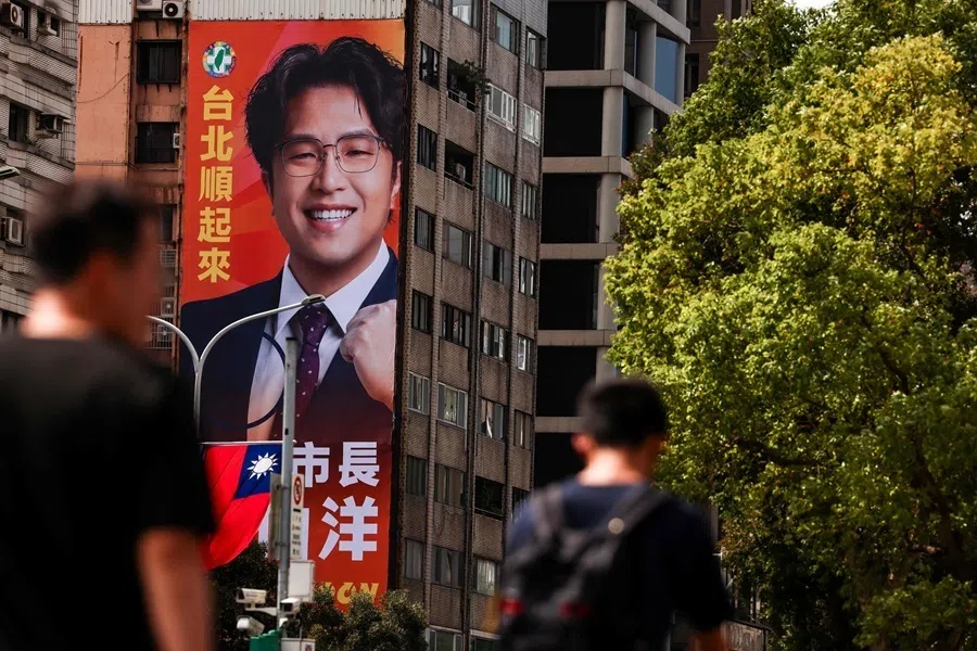 Pedestrians walk past a giant campaign billboard featuring the Democratic Progressive Party's Taipei mayoral candidate Puma Shen in Taipei on 15 October 2026.（I-Hwa Cheng/AFP）
