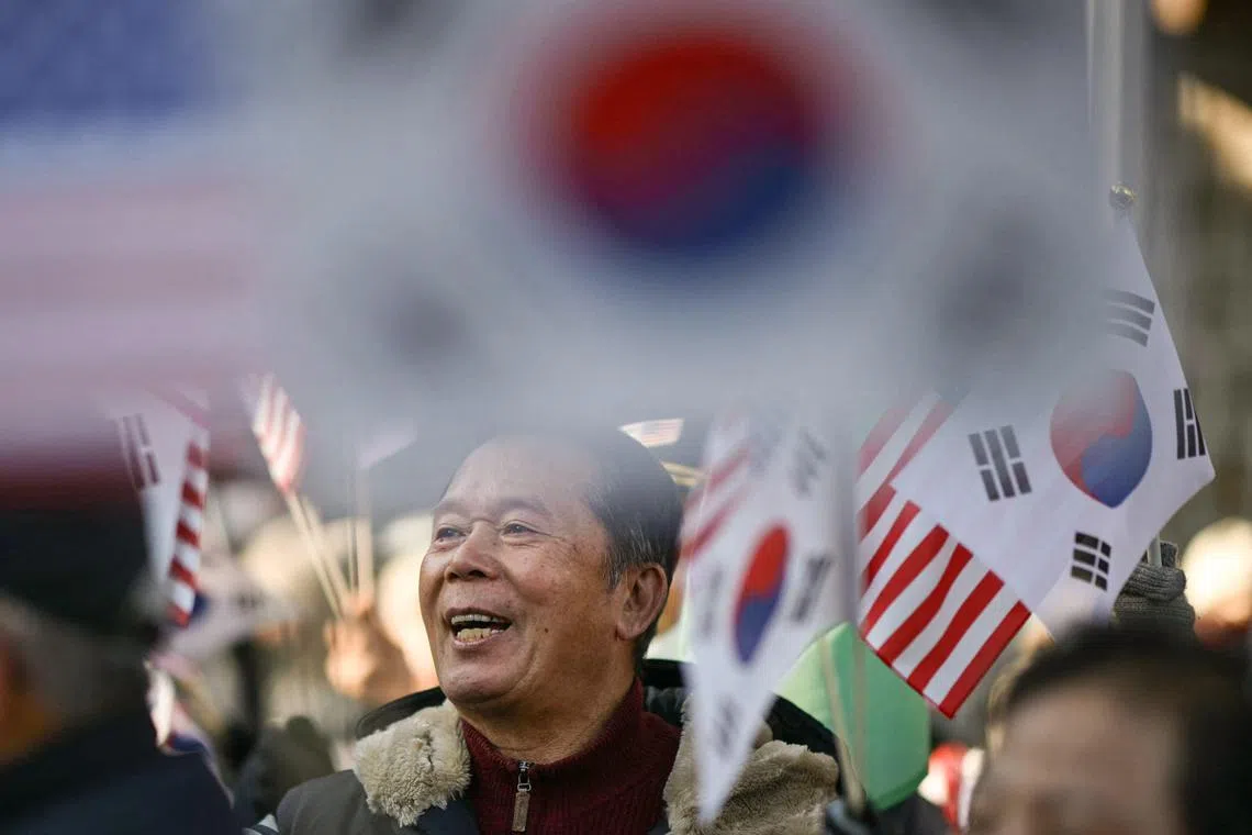 韩国总统尹锡悦星期二（12月3日）晚间无预警发布紧急戒严令后，面临被弹劾的风险，不少他的支持者隔天（4日）手持韩国和美国国旗上街游行，以示支持。（法新社）