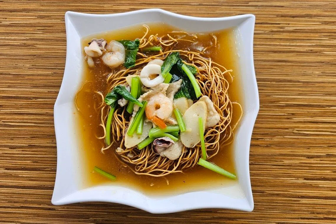 香脆生面勾上鲜浓芡汁，点缀青菜海鲜，令人垂涎。（黄亿敏摄）