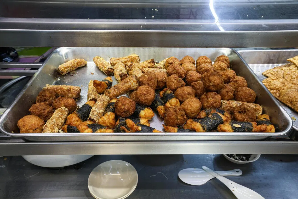 顾客认为，摊位的炸料选择丰富，包括肉丸、五香、紫菜肉卷等。（关俊威摄）