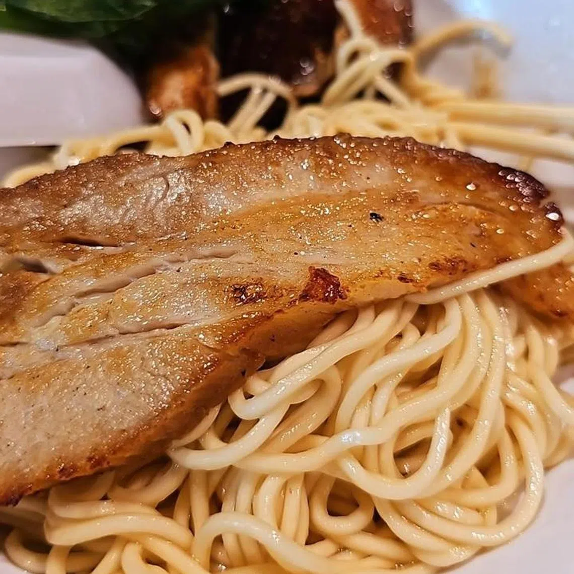 烤煎五花肉捞面的五花肉煎得特别香脆，油脂和肉汁交织很有满足感。（陈爱薇摄）