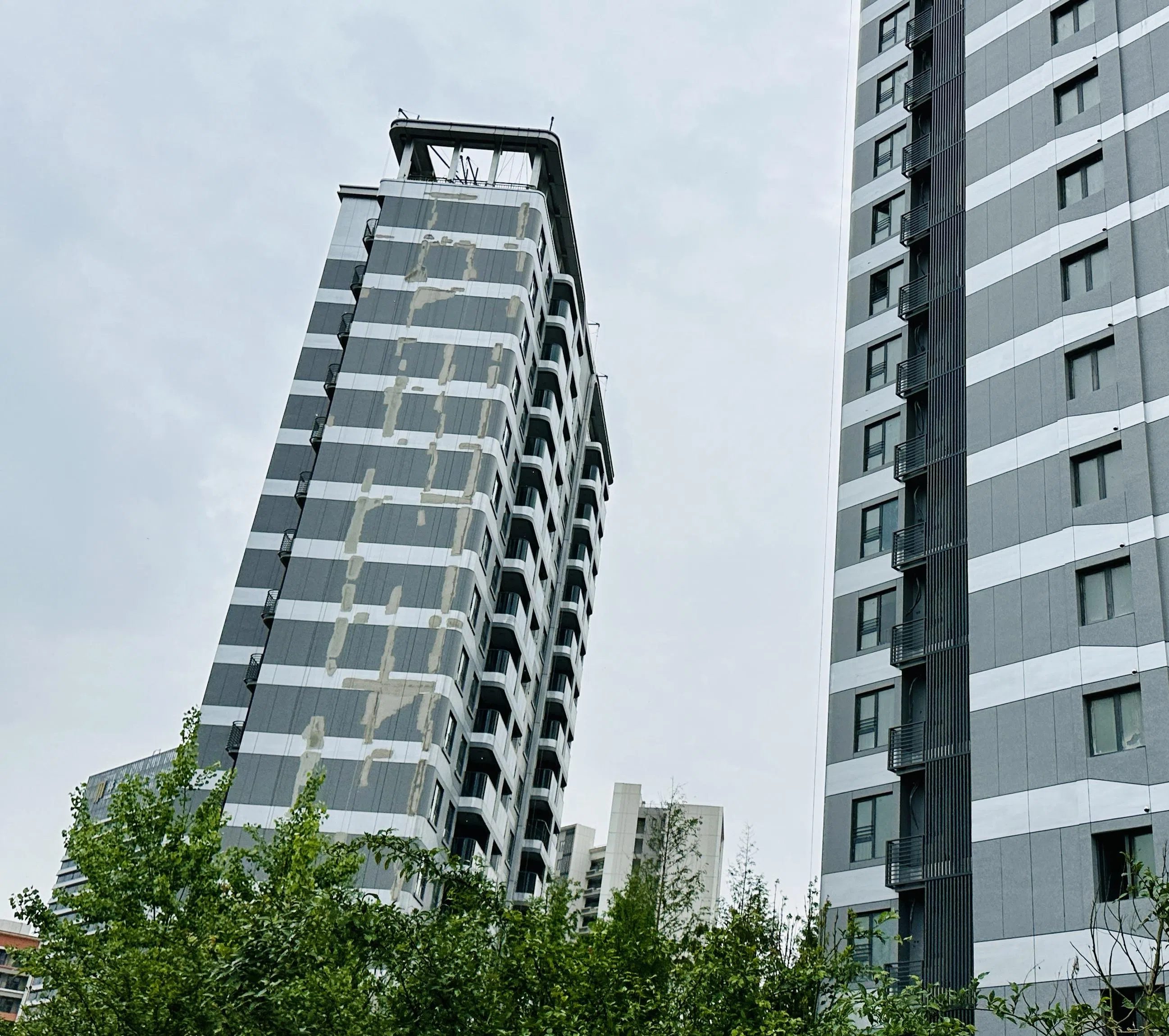 中建·玖海云天项目多栋楼房墙皮脱落，外墙斑驳。（陈婧摄）