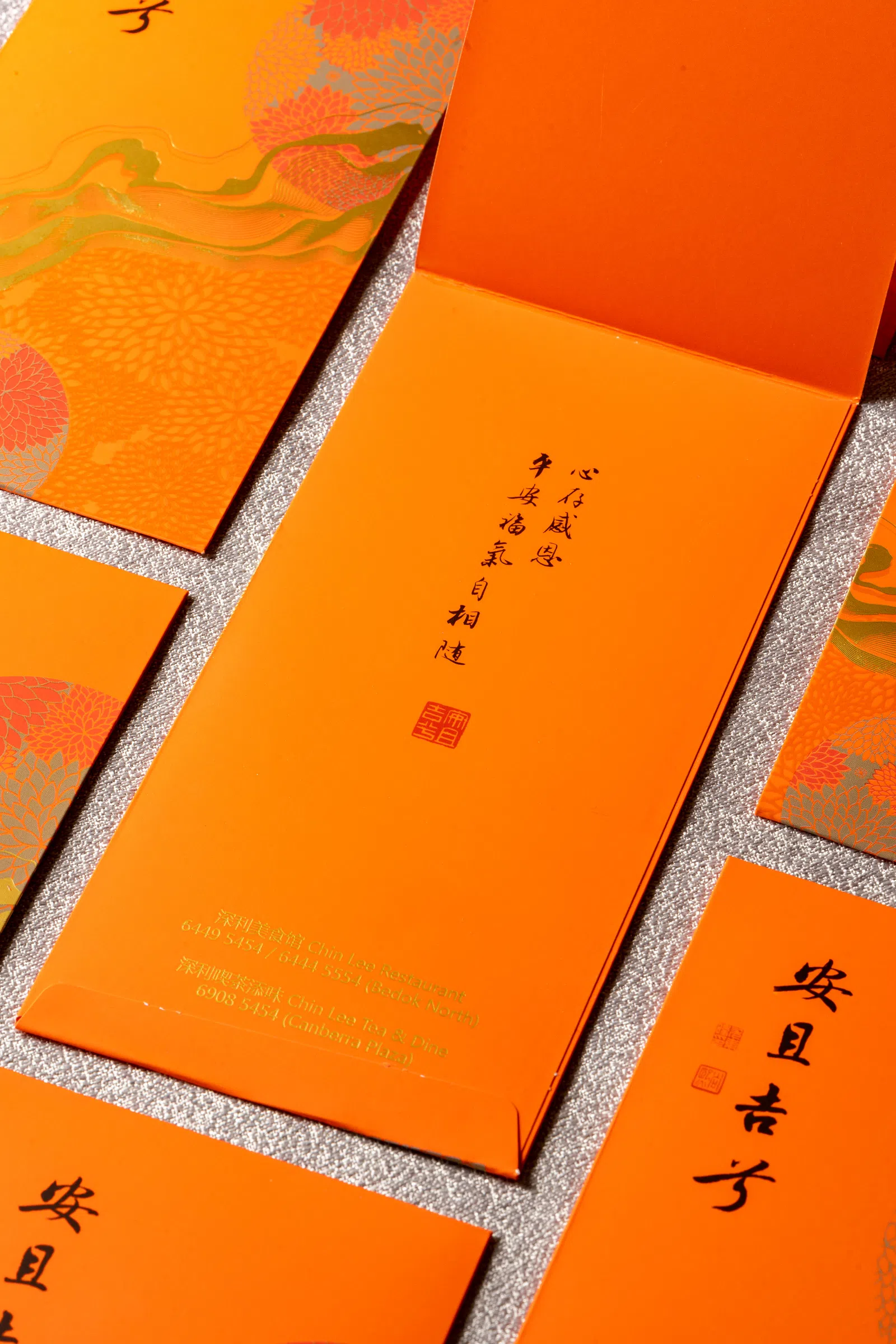 深利美食馆老板蔡春华积极推广新加坡书画艺术，今年和书画篆刻艺术家尤东暐医生合作的限量版红包。（餐馆提供）
