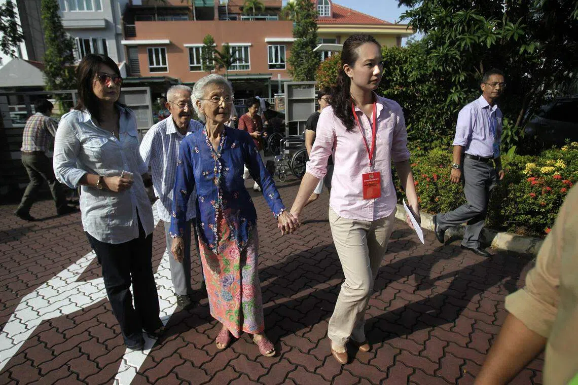 2011年大选，佘雪玲（右二）代表国民团结党参选，投票日当天偕同父母和祖父母前往投票。（海峡时报）