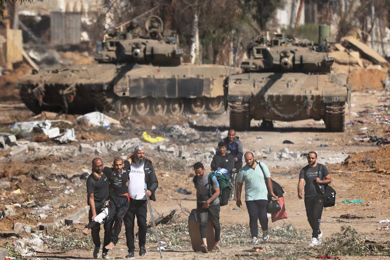 11月24日起，以哈停火四天，加沙北部平民赶紧逃离至南部郊区，他们背后是以色列坦克。停火协议过后两度延长。（法新社）