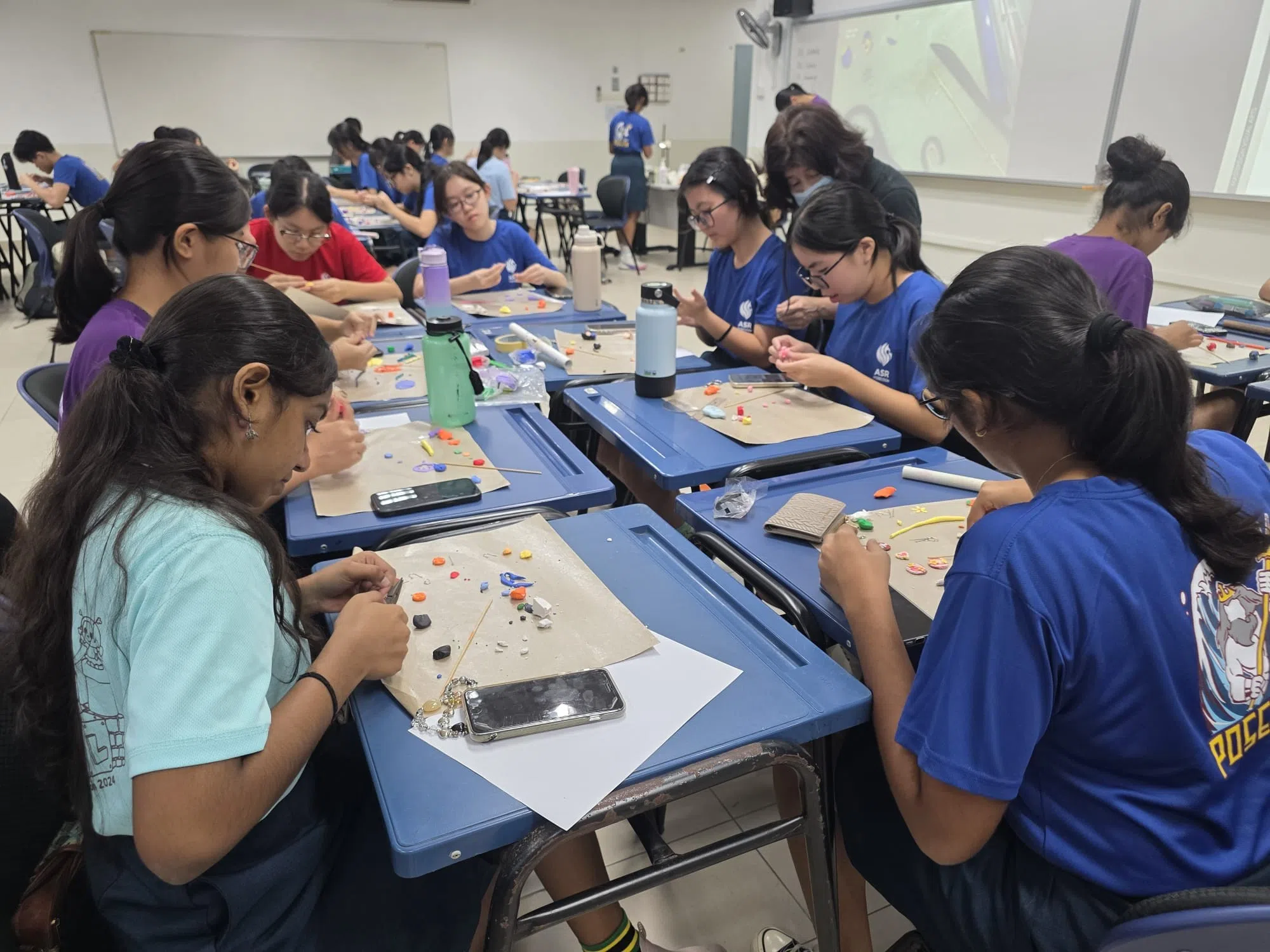 在制作软陶首饰的教室里，学生们聚精会神地操作手中的材料，小心翼翼地组合图案，制作出精致的饰品。（安德逊实龙岗初院提供）