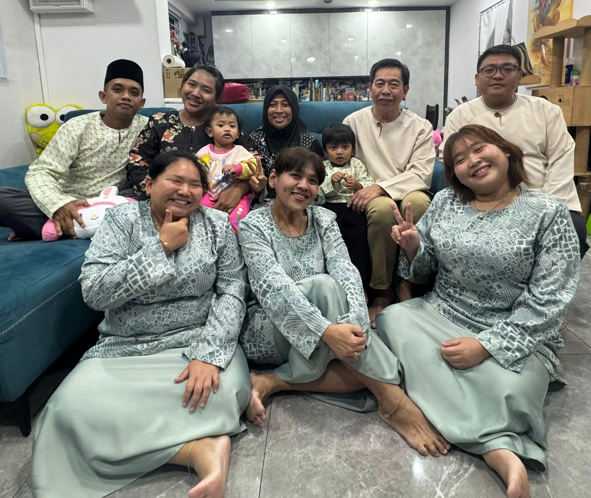 珠爱林（前排中）与父亲珠客伟（后排右二）、母亲诺丽塔（后排中）,以及弟弟元到（后排右一）、老三凯林（后排左二）和她丈夫及子女、老四志林（前排左）和小妹玉林（前排右），去年开斋节在家中拍摄的全家福。（受访者提供）