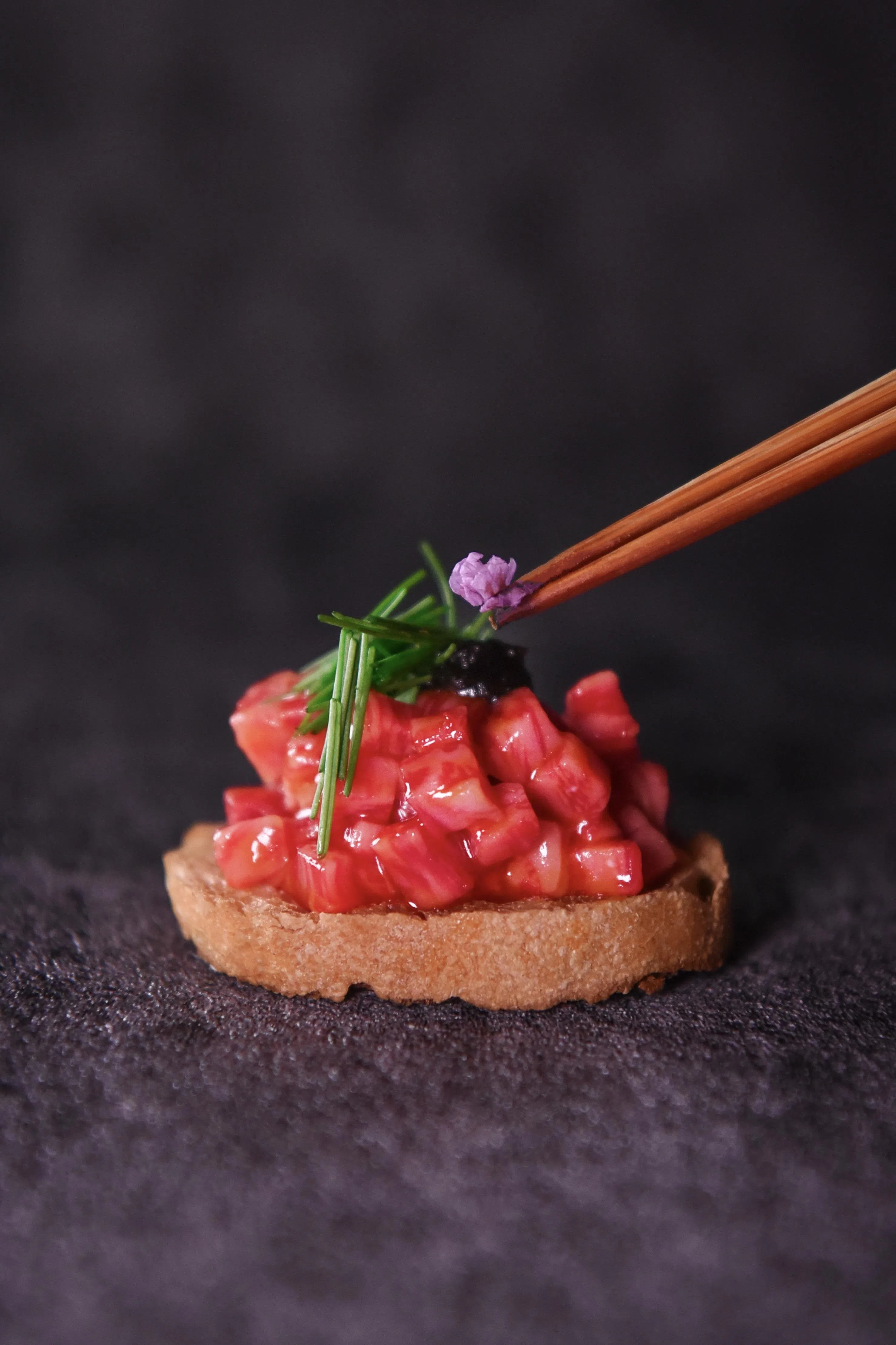 松阪牛鞑靼以手工切丁调味，铺放在蒜香法棍上。（餐馆提供）