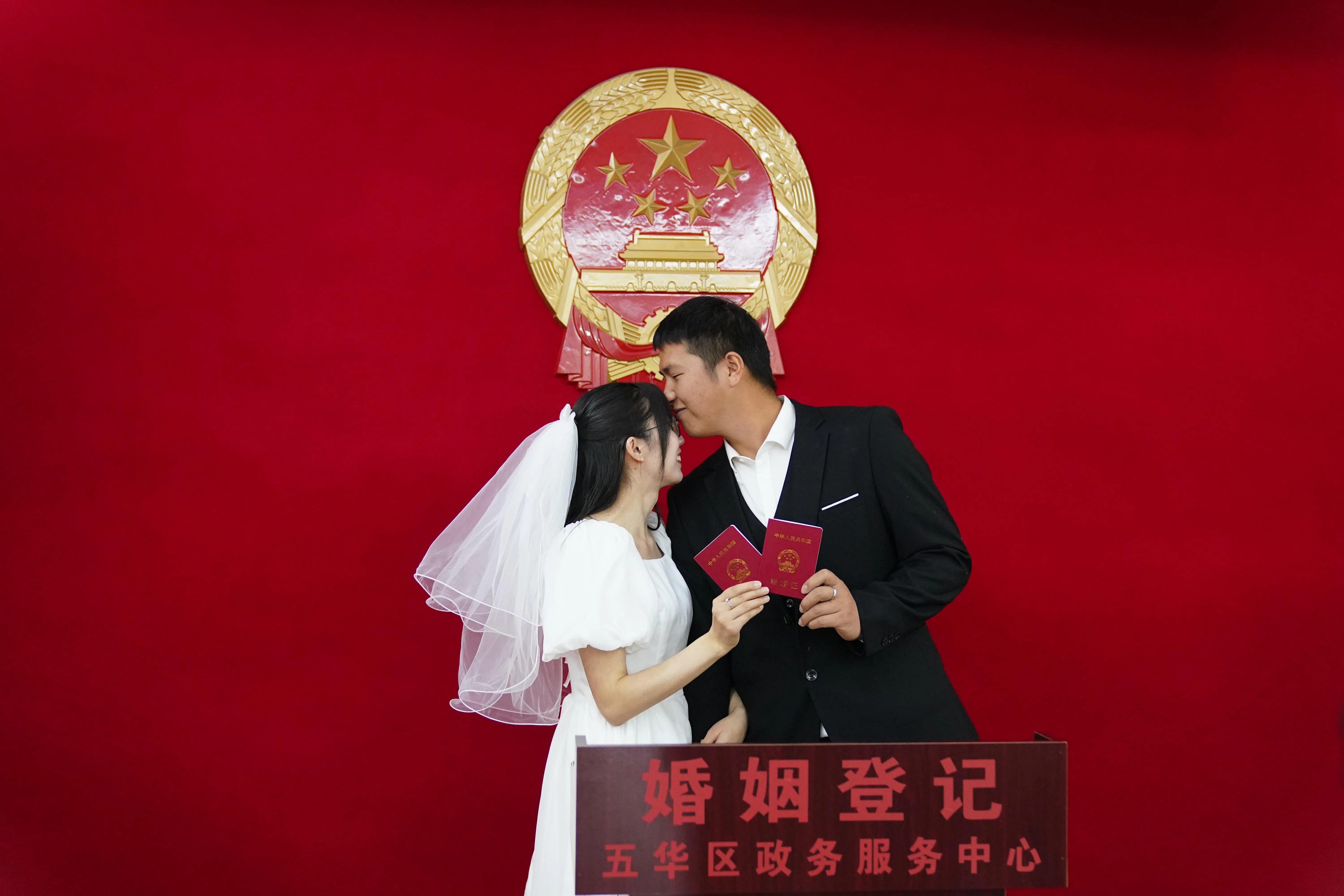 随着婚姻观念的改变，中国上半年结婚登记对数继续下滑。图为云南省昆明市一对新人领取结婚证后拍照留念。（香港中通社档案图片）