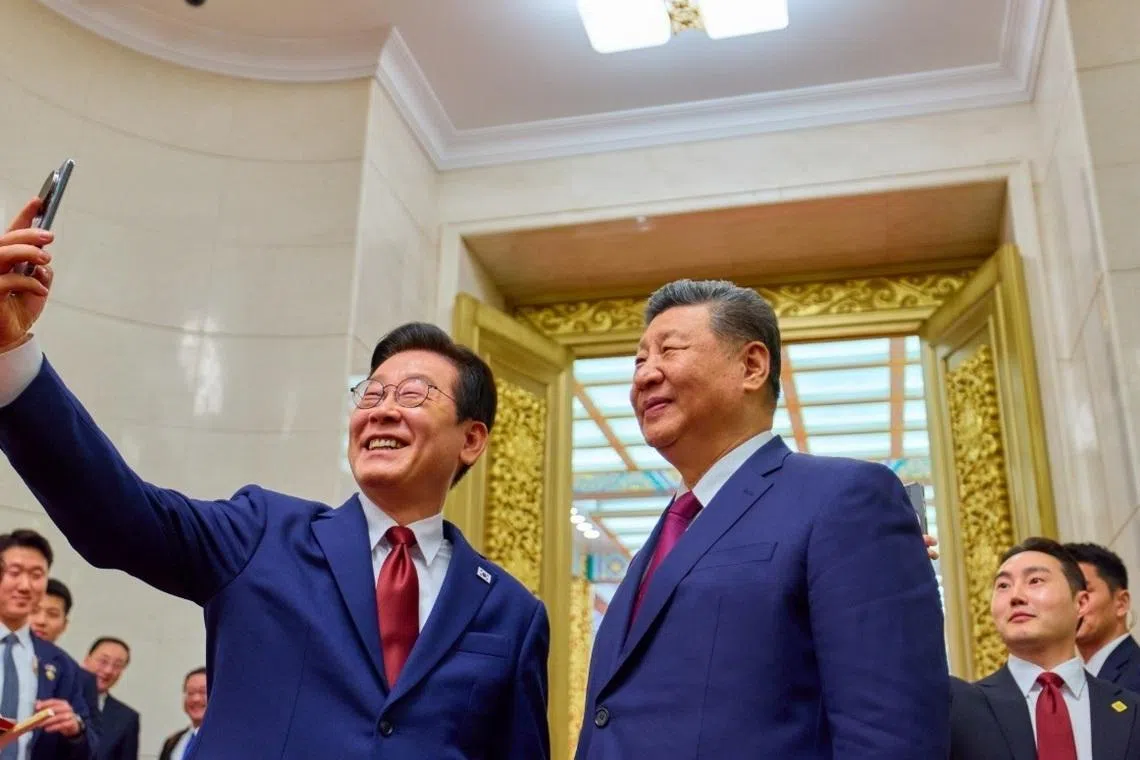 韩国总统李在明（左）星期一（1月5日）在北京人民大会堂，用中国国家主席习近平（右）所赠的小米手机，与习近平自拍。（取自李在明X账号）