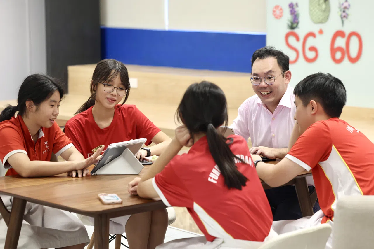 邱勇康（中）教书最大的动力来自学生，他们在中学四年里的成长与成熟，是他坚持下去的原因。（陈斌勤摄）