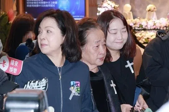 袁惟仁高龄母亲（中）在杨贵媚（左）搀扶下离开灵堂。（互联网）