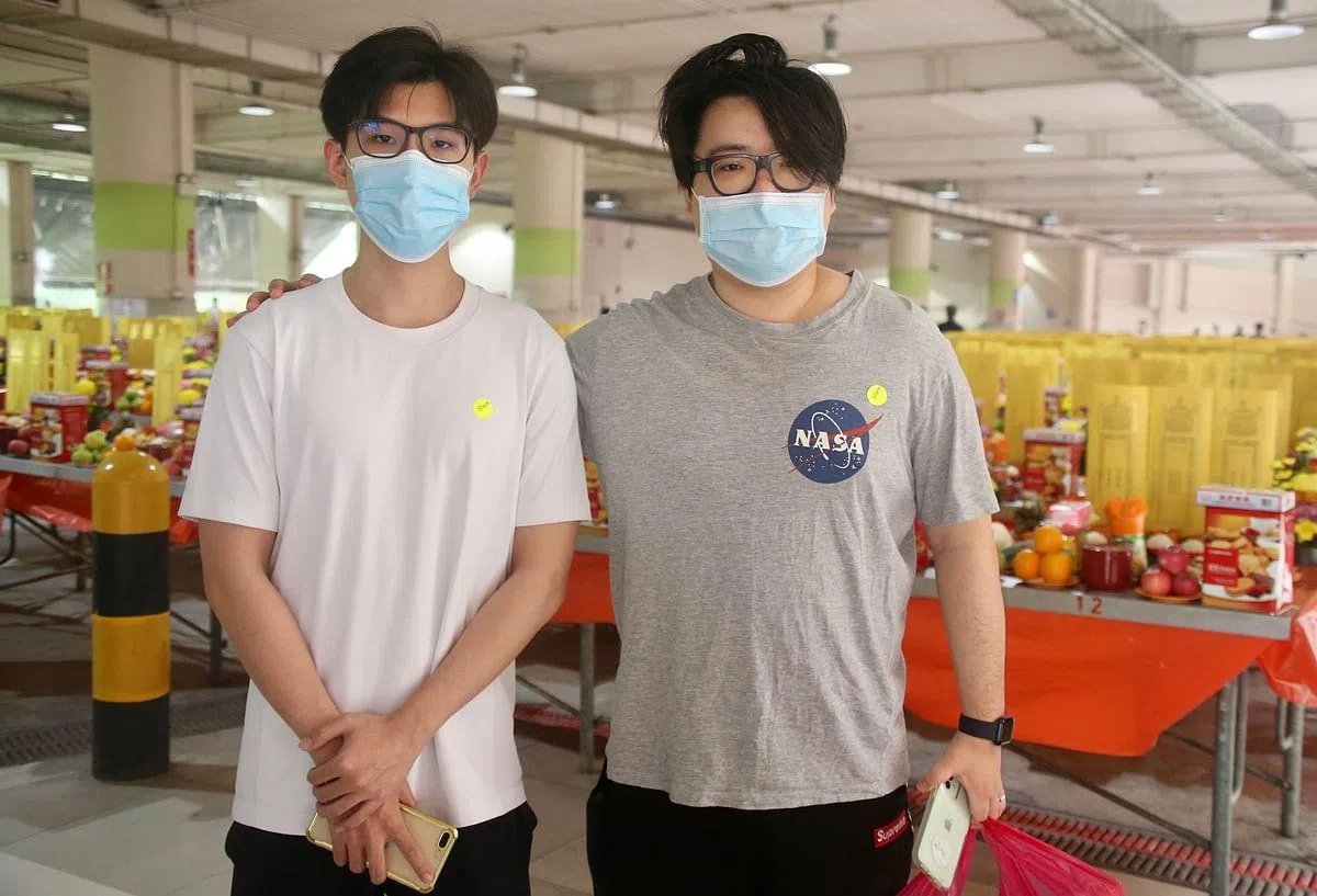 高泓南（右一）和高骏（左一）一起来祭拜先人。（邬福梁摄）