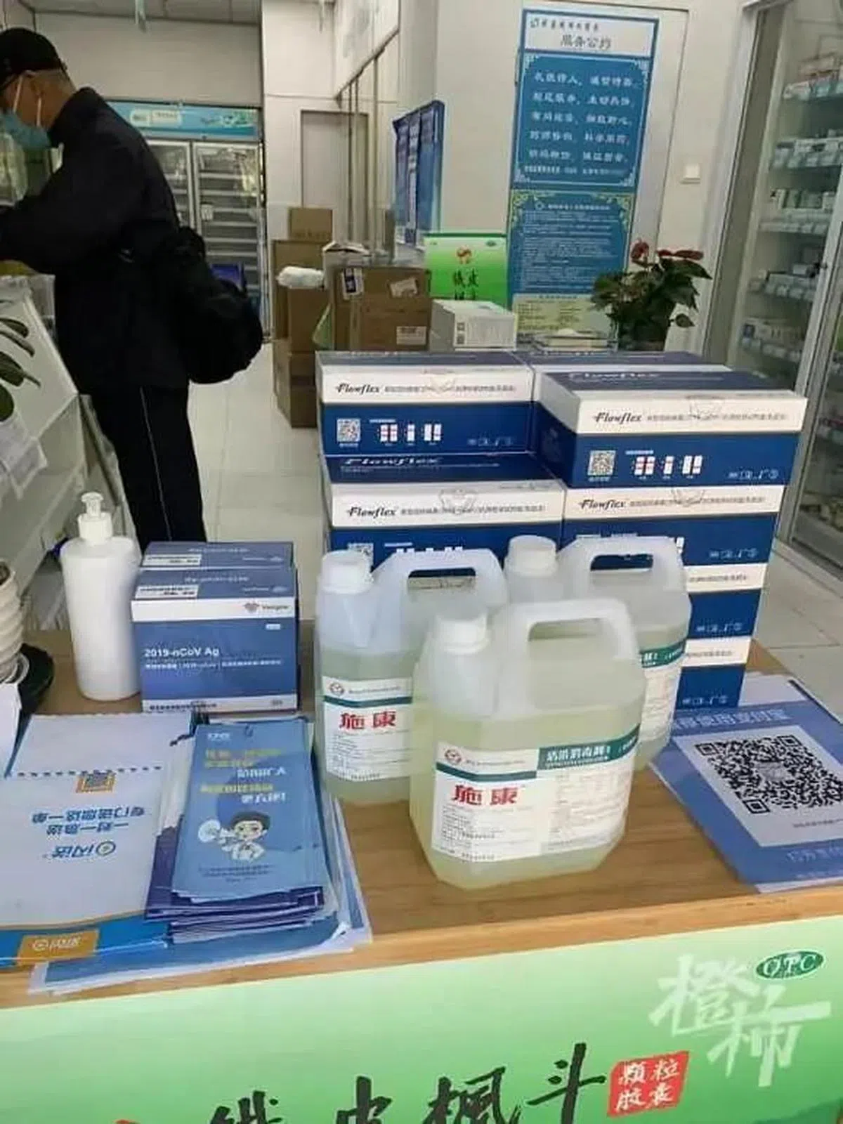 位于杭州市丰潭路上的一家华东武林大药房，大门口的桌子上堆放着两种不同规格的抗原检测试剂。（互联网）