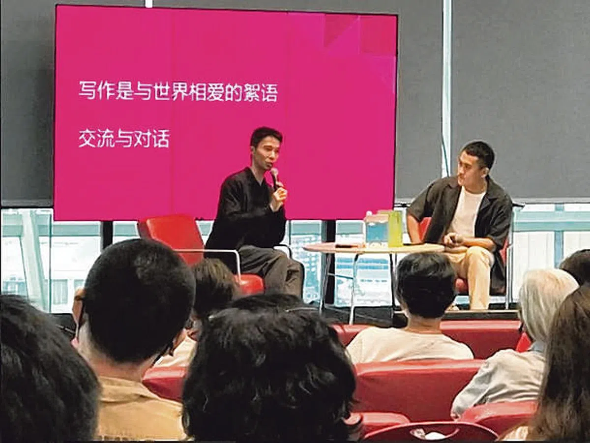 梁海彬（左）呼吁大家忙里偷闲，去阅读、写作，去与世界相爱。右为主持人陈宇昕。（新加坡书展提供照片）