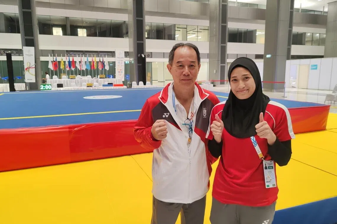 卡蒂嘉（右）星期六成功锁定武术散打奖牌后，和我国散打主教练黄文福合照。（陈明耀摄）