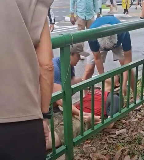 少年被救出后，被路人带到路旁休息。（ROADS.sg视频截图）