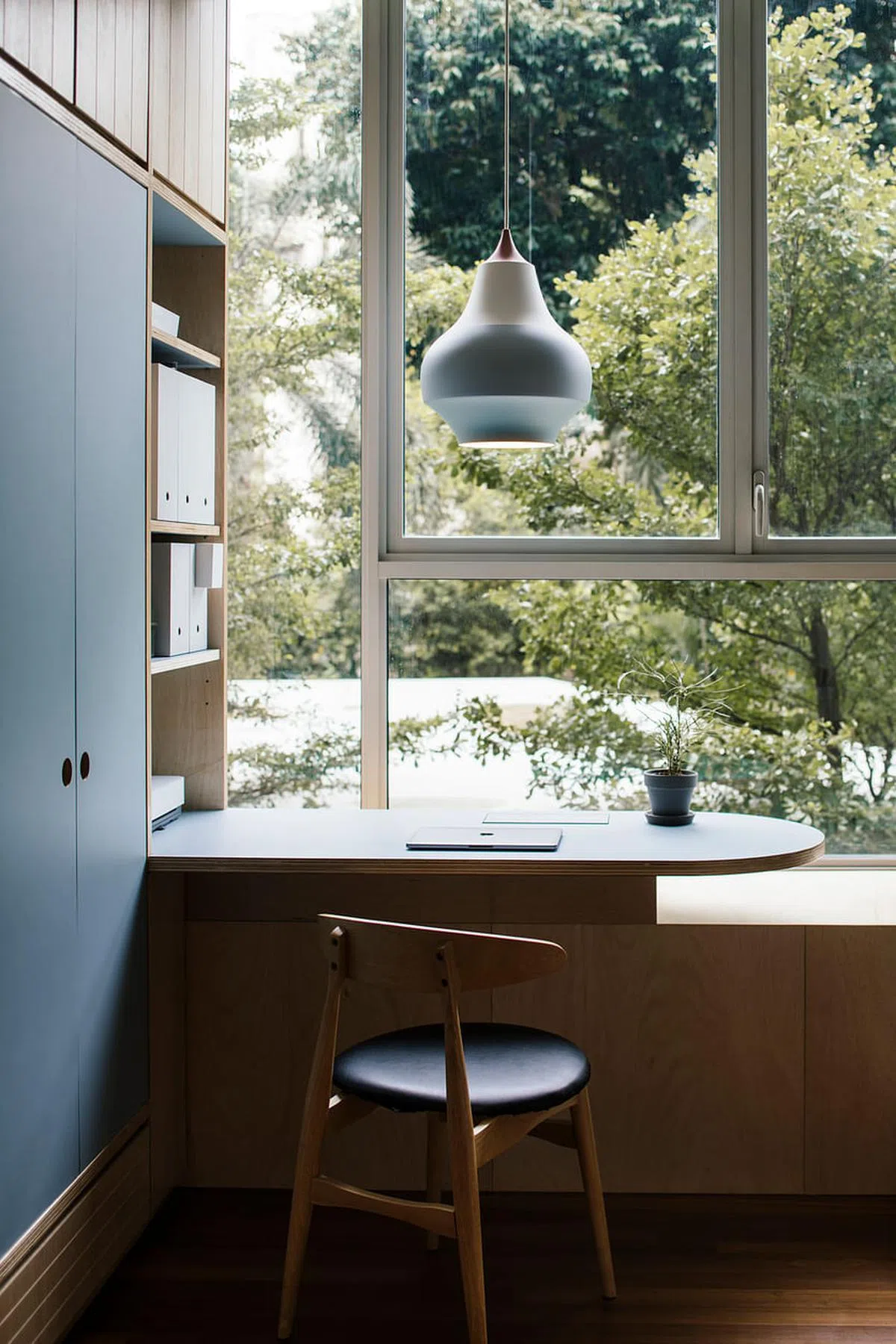 淡灰蓝色的半圆书桌面对窗外郁郁葱葱的树影，让人顷刻放松心情。