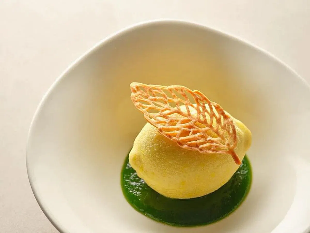 柠檬造型的甜品，敲开白巧克力外壳，就能品尝到酸酸甜甜的柠檬青柠奶油。（餐馆提供照片）