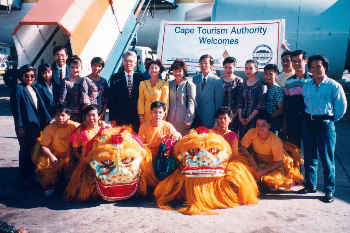1994年，林惟明（后排右二）和陈清发（前排中间）随舞狮团赴南非开普敦，与新航人员合影。（新加坡精武体育会提供）