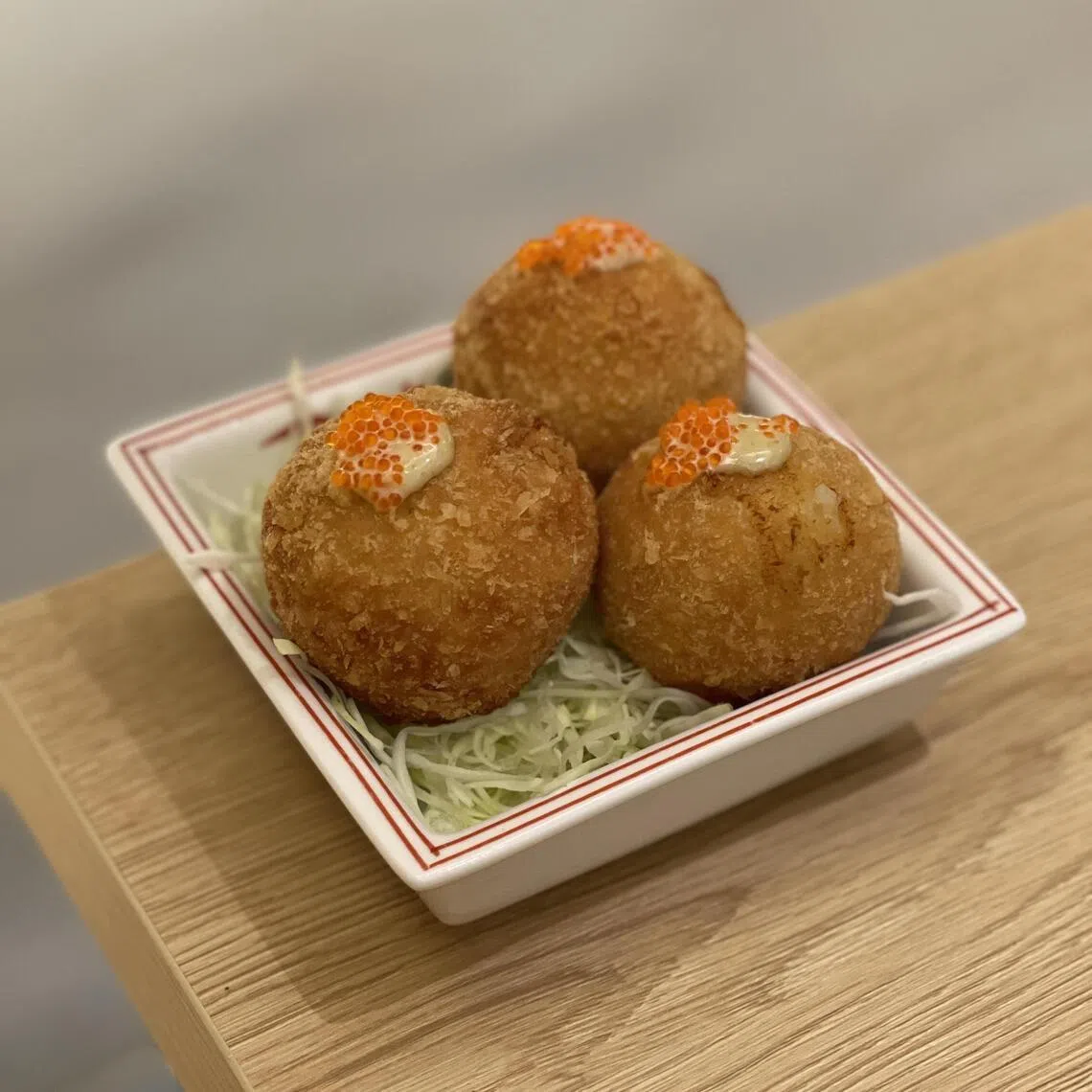 虾肉可乐饼外酥里嫩，蘸些许柚子胡椒蛋黄酱，口感层次丰富。（黄靖晶摄）