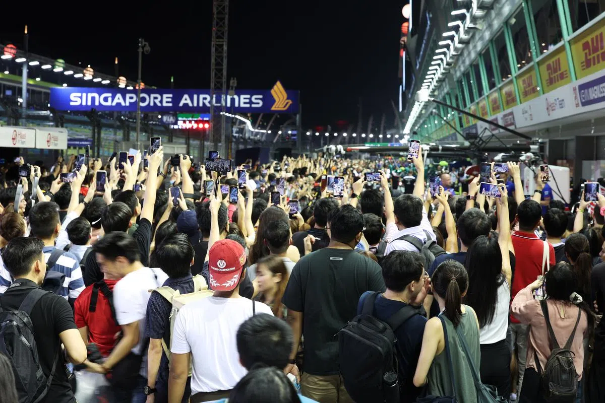 F1维修站大楼星期四开放给公众，大批成功索票的公众高举手机对准车队猛拍。（张思庆摄）