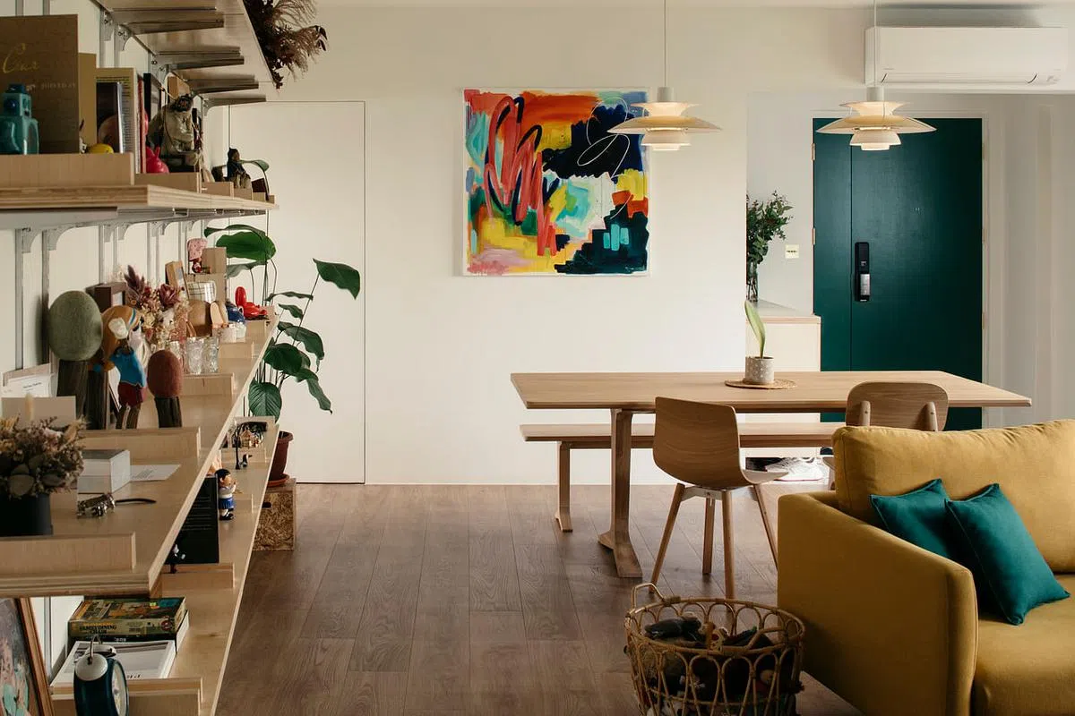 饭桌墙面挂了一幅五颜六色、奔放自如粗色块和线条的画作，满足男主人对色彩的追求。
