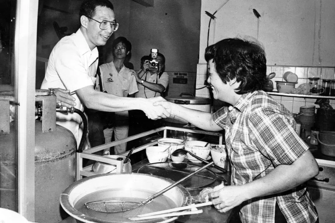 32岁的李显龙准将（左一）于1984年9月23日以角逐德义区的人民行动党候选人身份访问德义区居民。（档案照片）