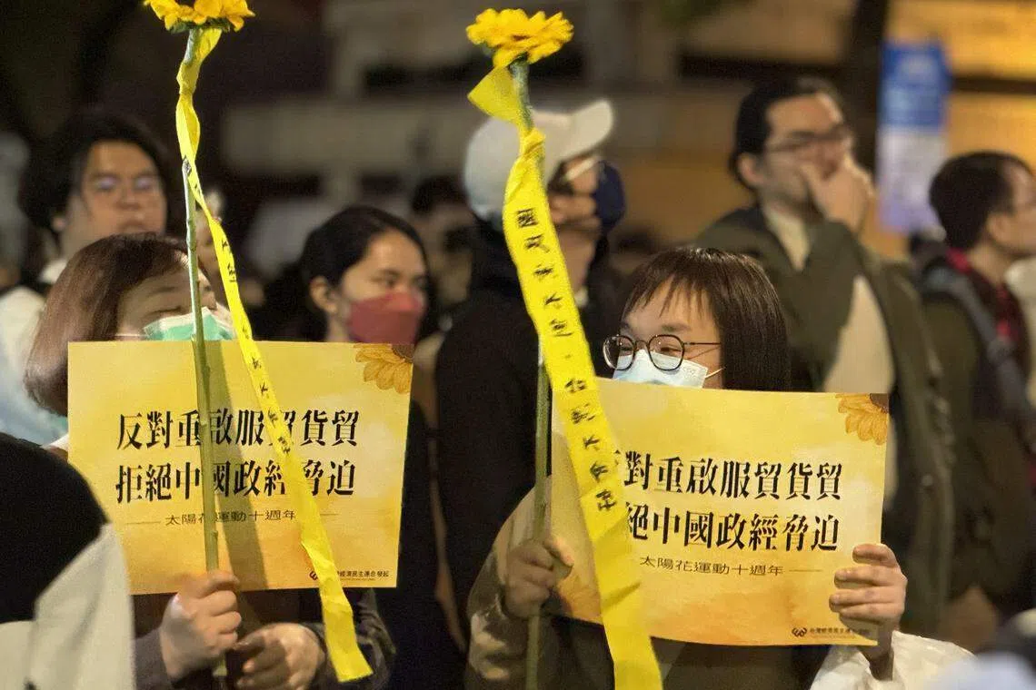 台湾民间团体3月18日在立法院旁举办太阳花学运十周年晚会， 民众高举“反对重启服贸货贸，拒绝中国政经胁迫”的标语。（缪宗翰摄）