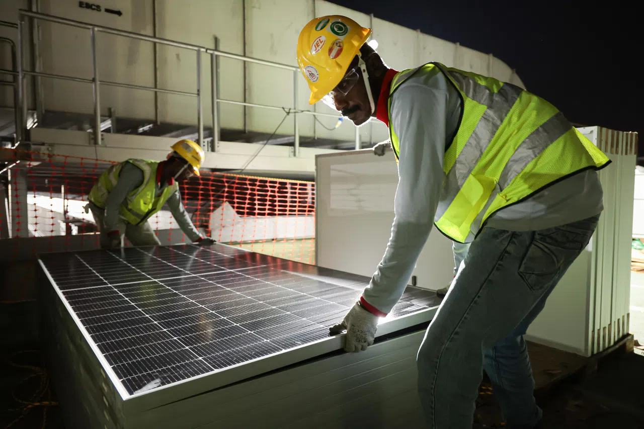 建筑顶层有另20多个工作人员井然有序地进行安装工作，每晚能安装700多个太阳能板。（李冠卫摄）