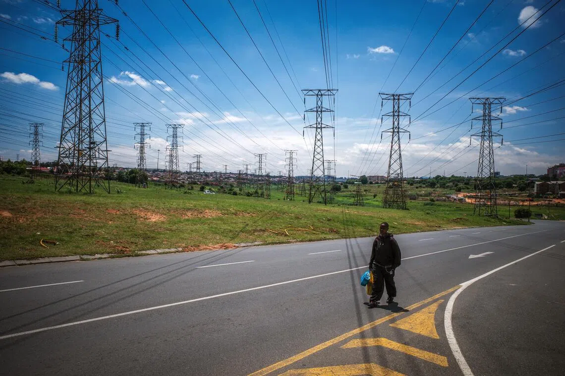 在电缆交织的天空下，每一个孤独背影，都藏着向往光明的微小愿望。（叶振忠摄）