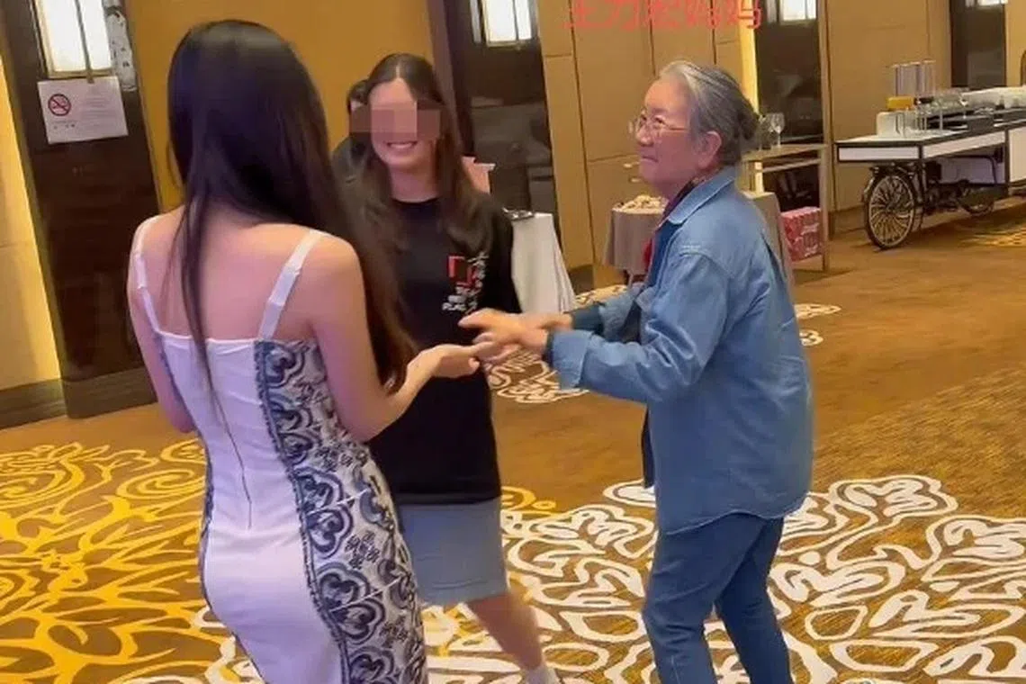长发妹（左，背向镜头）与王力宏母亲（右）在庆功宴上牵手起舞。（取自微博）