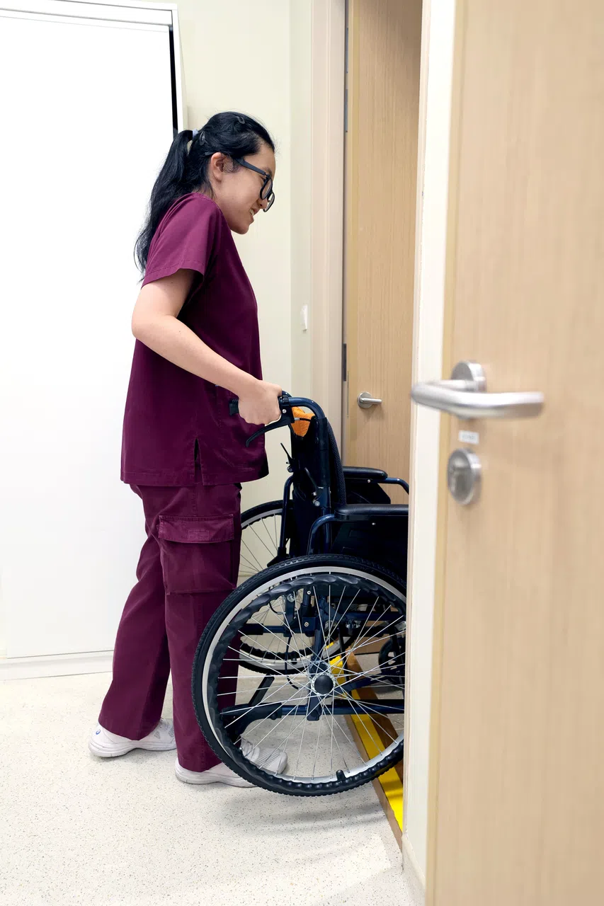 跨过路缘的错误做法：仅凭手臂蛮力将轮椅后倾并抬高轮椅。（龙国雄摄）