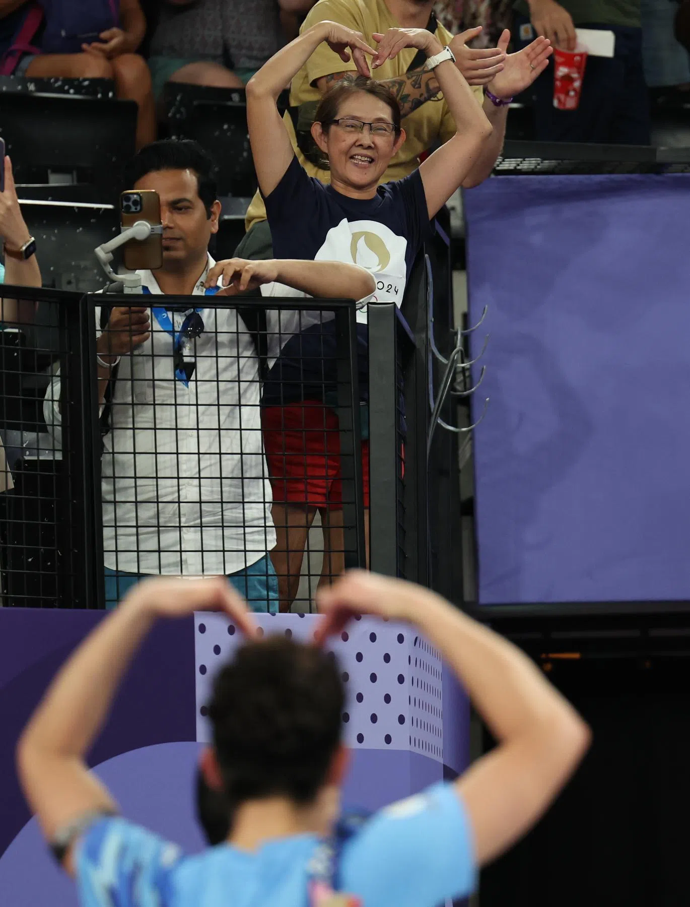骆建佑（下）在获胜后与母亲（上中）相互比心庆祝。（新加坡体育理事会提供）