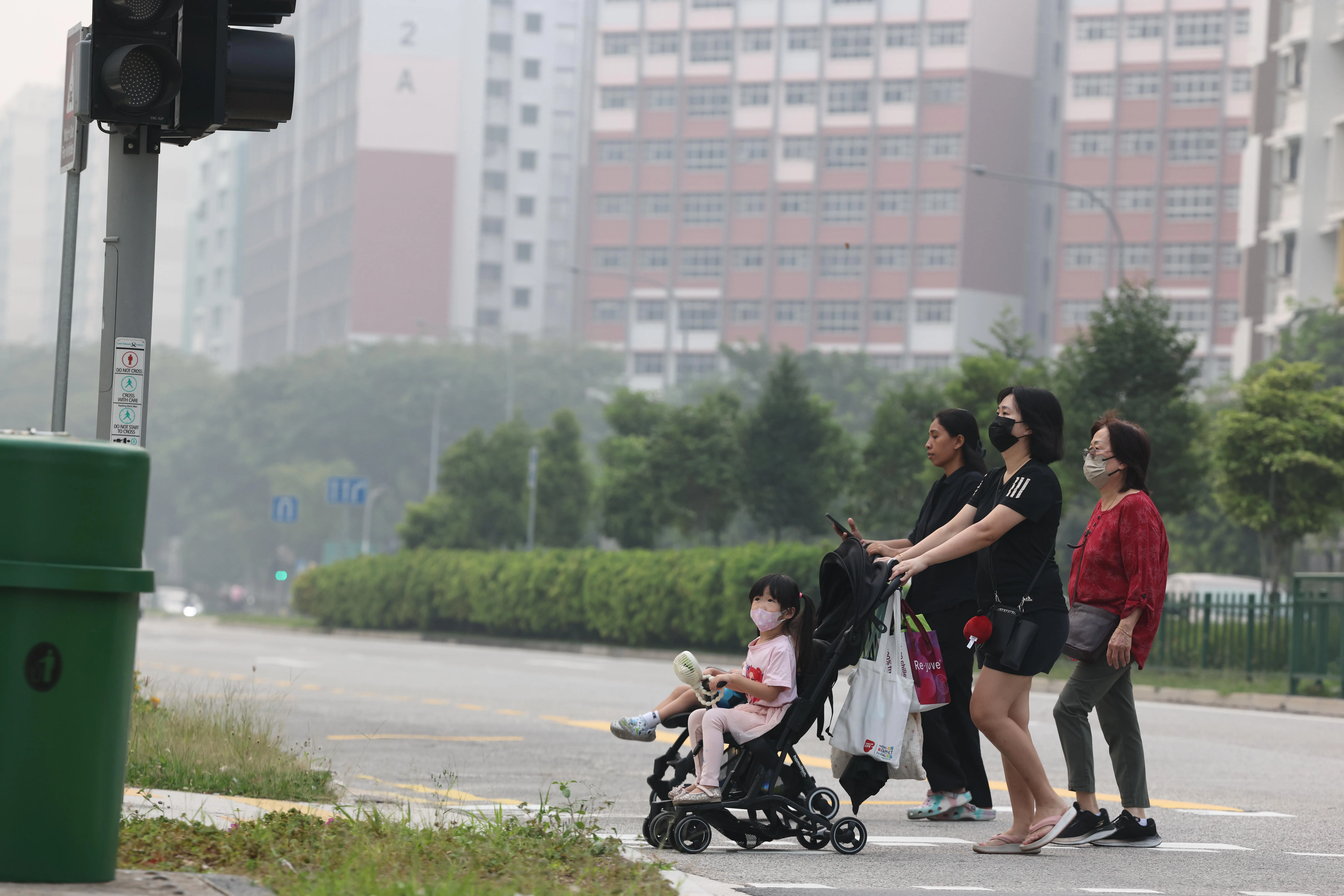 全岛五个地区的24小时空气污染指数（PSI）继续攀升，不少公众戴口罩出门。（邝启聪摄）