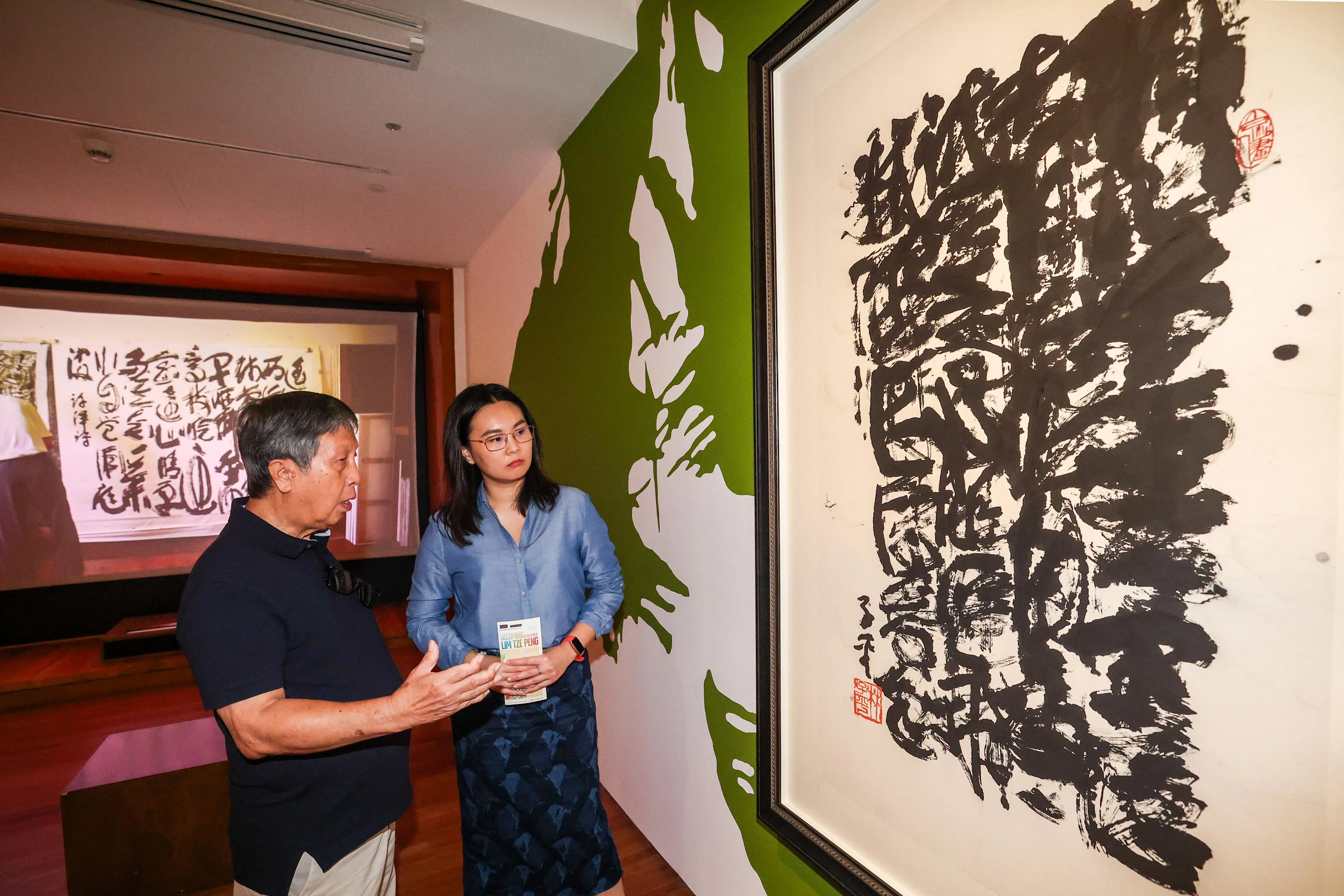 展览顾问姚梦桐（左）和策展人林家欣在讨论林子平的“糊涂字”。（陈斌勤摄）