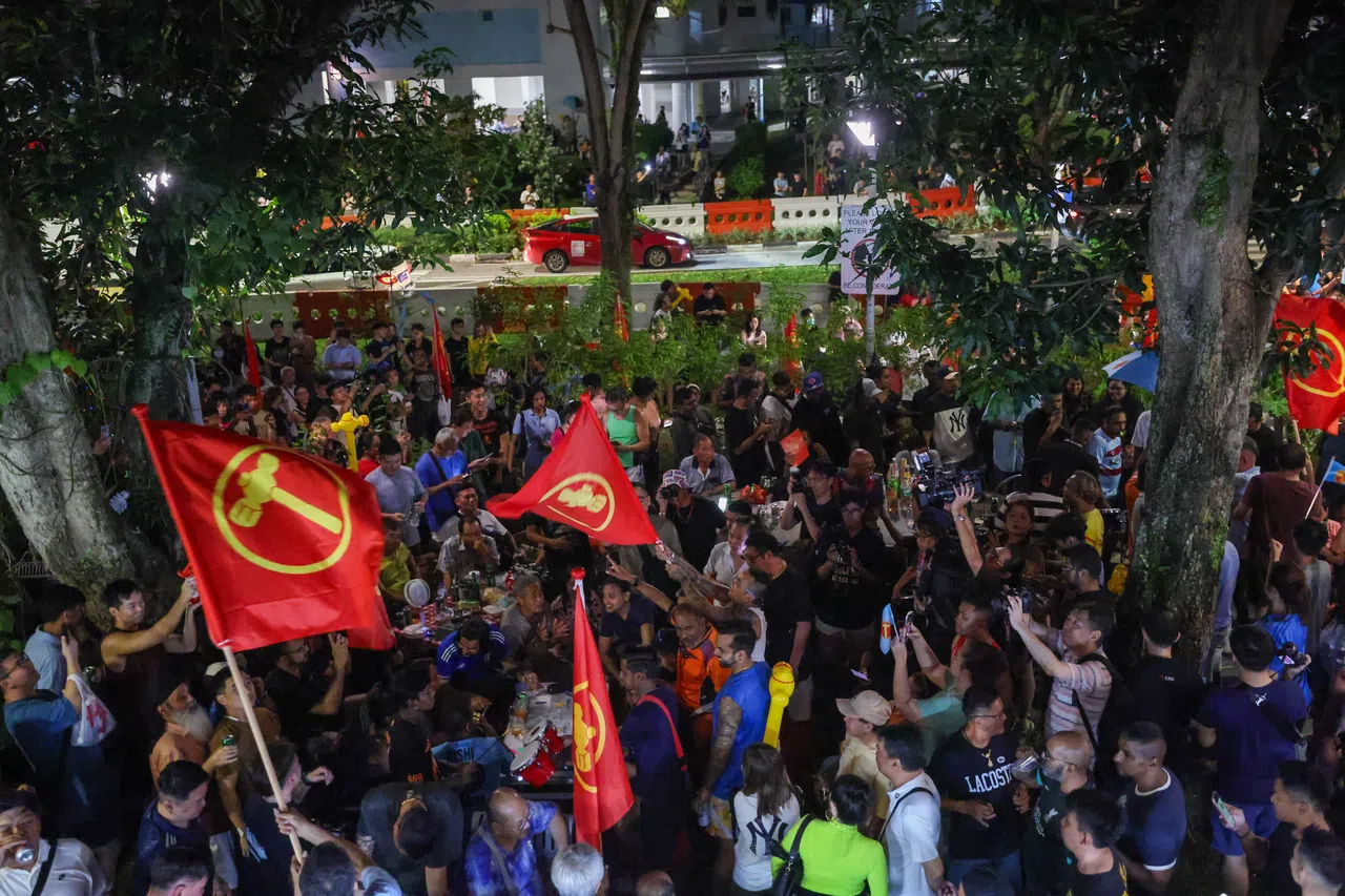工人党支持者5月3日在全国大选开票当晚，聚集在后港5道第322座组屋的“燕飞来”咖啡店周围，等候开票结果。（白艳琳摄）