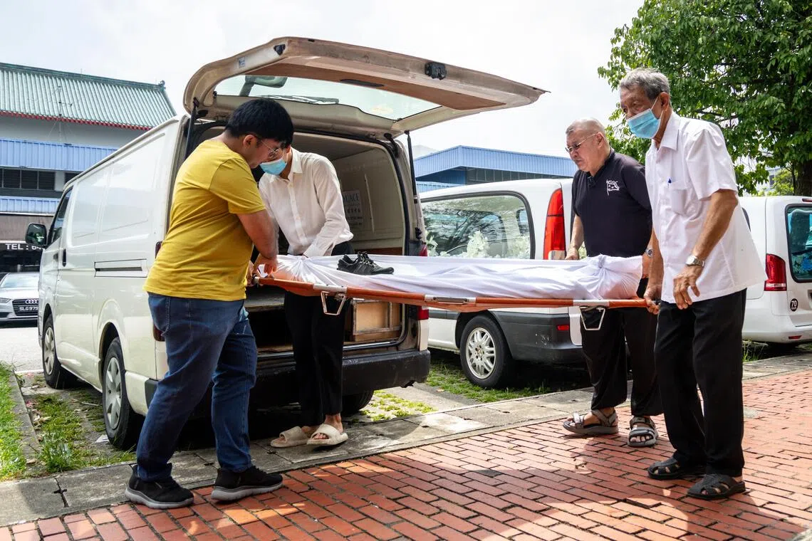 俞肇斌（右二）接到电话后，上午11时赶到慈怀中心接收遗体，然后送到新民路寿板店入棺。（叶振忠摄）