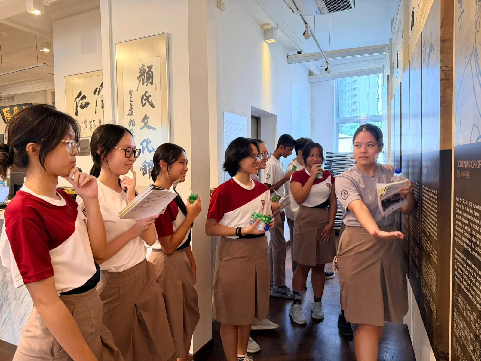 学生导览员毛俪颖（右一）分享不同时代颜氏的代表人物。（照片由淡滨尼美廉初级学院提供）