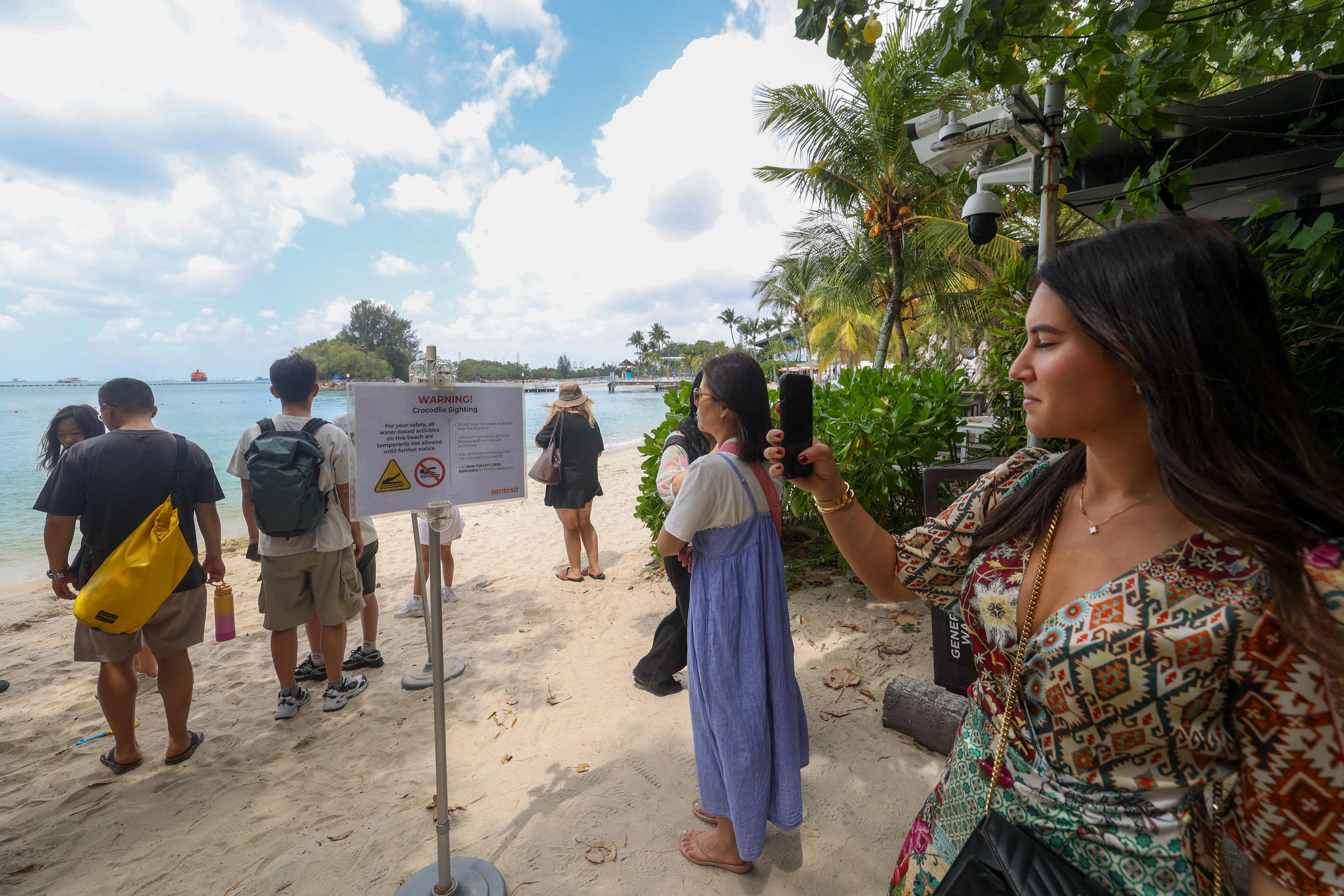 圣淘沙西乐索海滩竖起鳄鱼出没警告告示，游客只能在沙滩上玩，不能下水。（吴先邦摄）