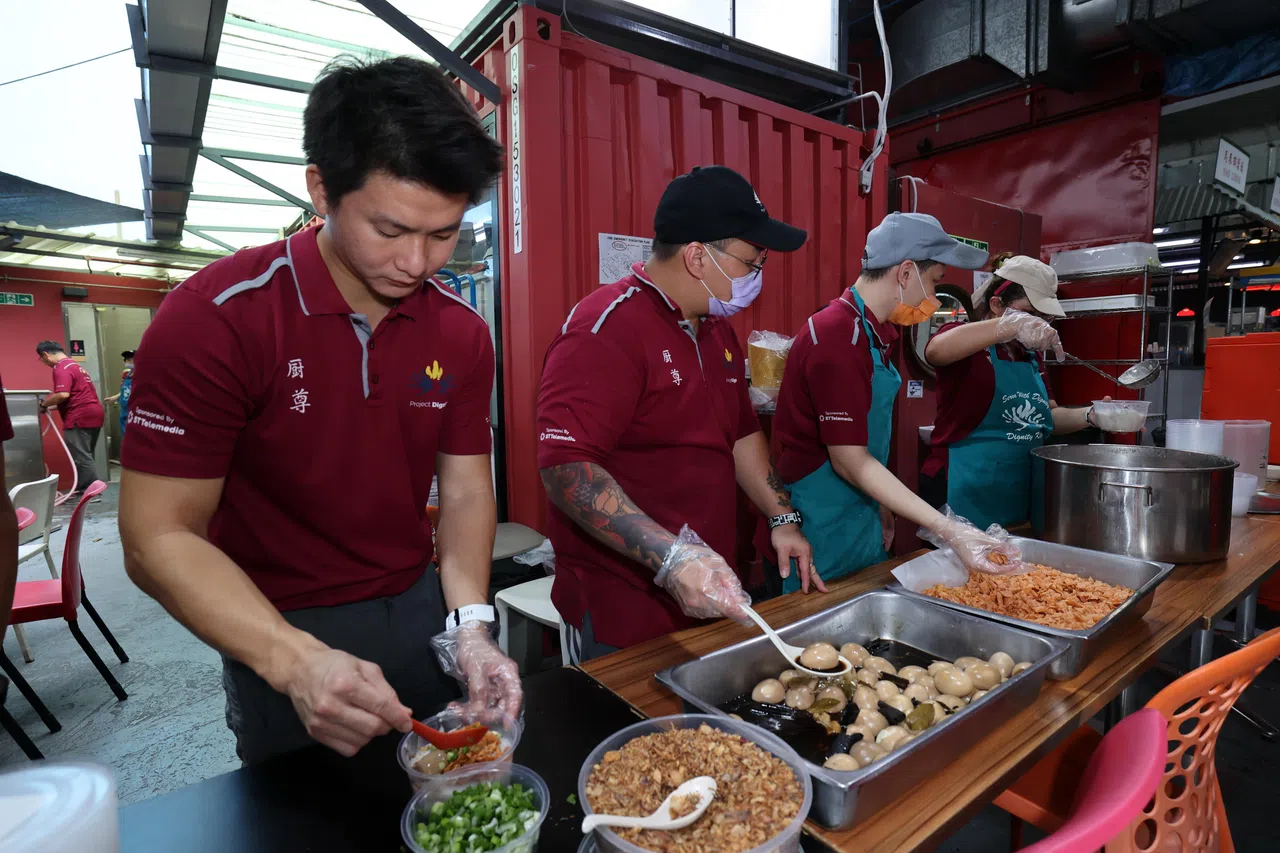 许嘉玮（左）在厨尊什么都得学，包括“打包”食物，派送给附近有需要的居民。（梁麒麟摄）
