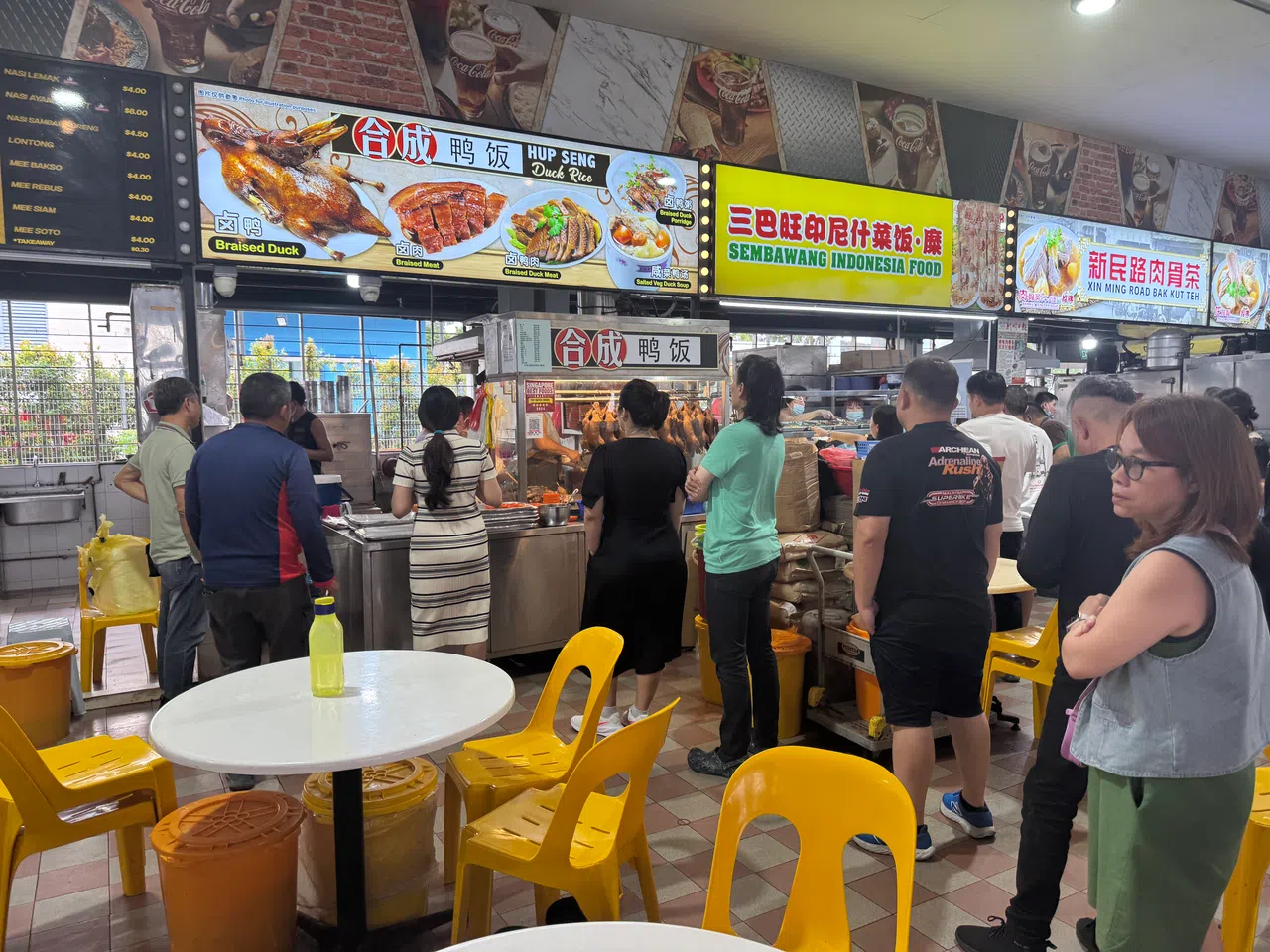 饭点时间，合成鸭饭档口排起长长人龙。（翁铭芯摄）