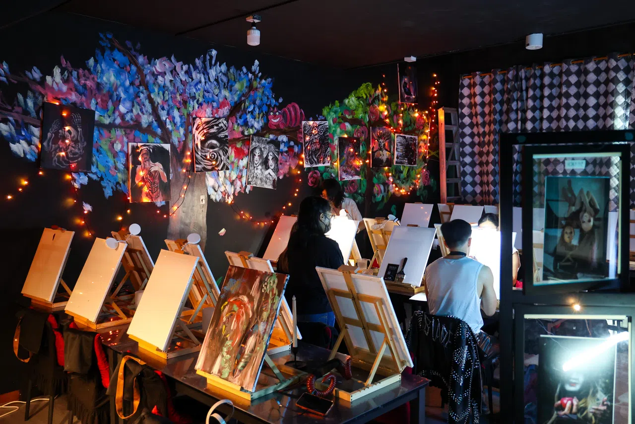 体验者沉浸在幽暗的环境中作画。（林明顺摄）