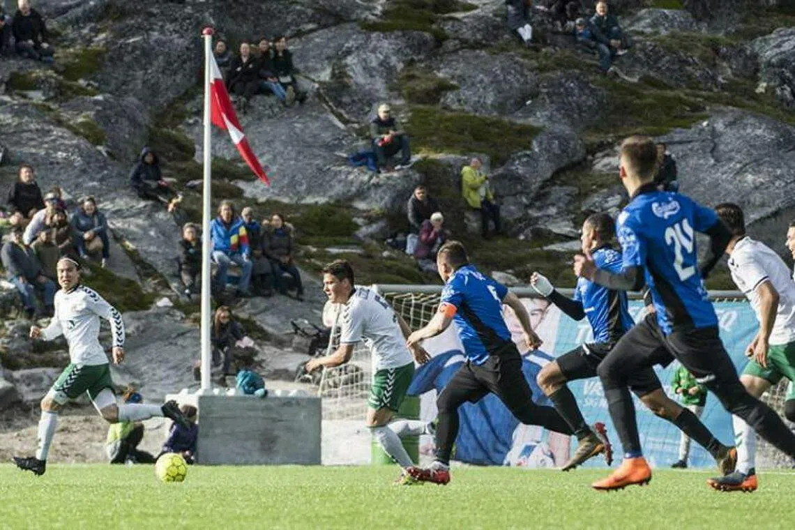 今年的格陵兰联赛在南部城市卡科尔托克举行。球场没有观众席，观众就坐在岩石上观看。（取自格陵兰媒体Sermitsiaq.AG官网）