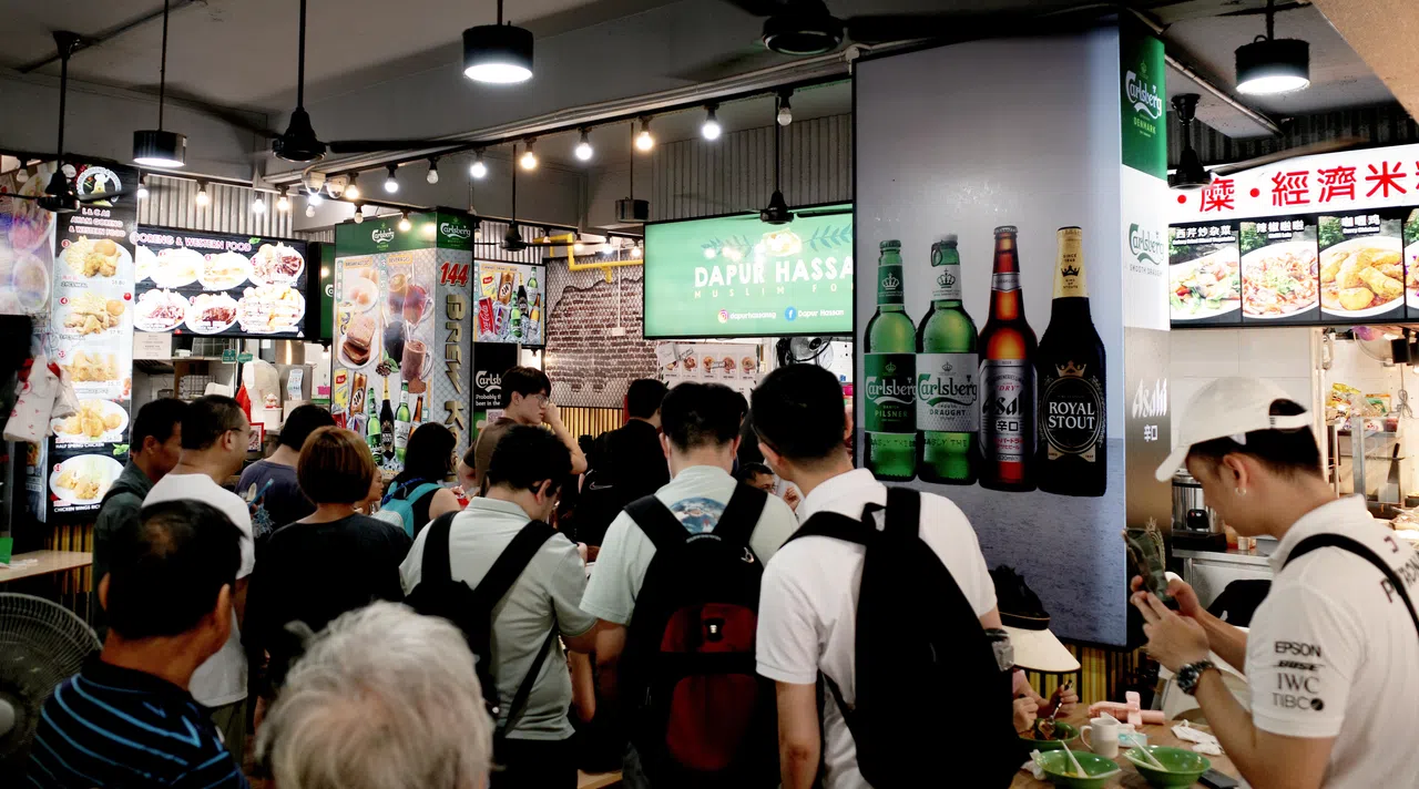 球迷们在哈山厨房前排队的盛况。（卓舒畅摄）