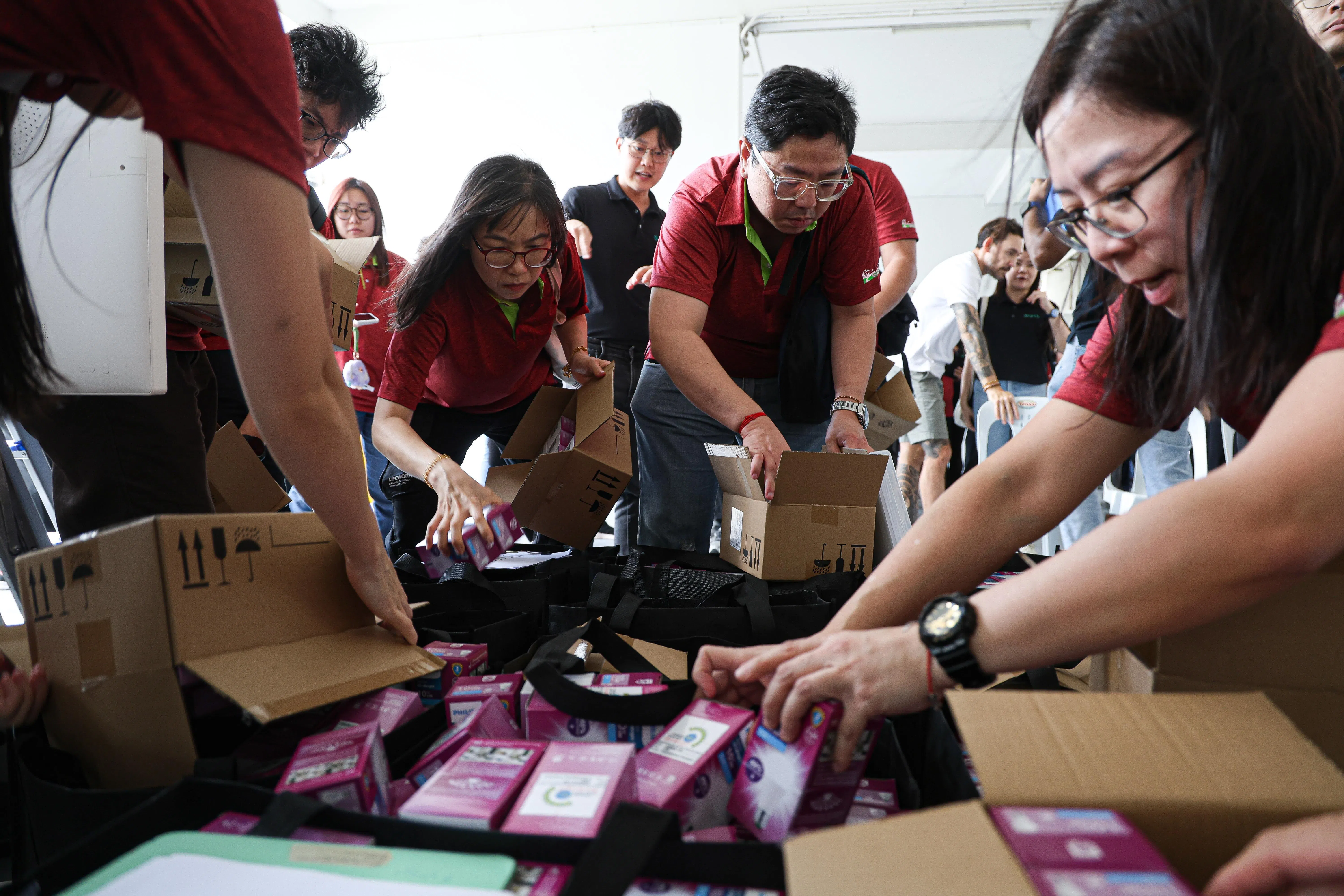 碧山—大巴窑市镇理事会和昕诺飞的工作人员和义工，一起为低收入租赁组屋家庭准备节能灯泡。（关俊威摄）