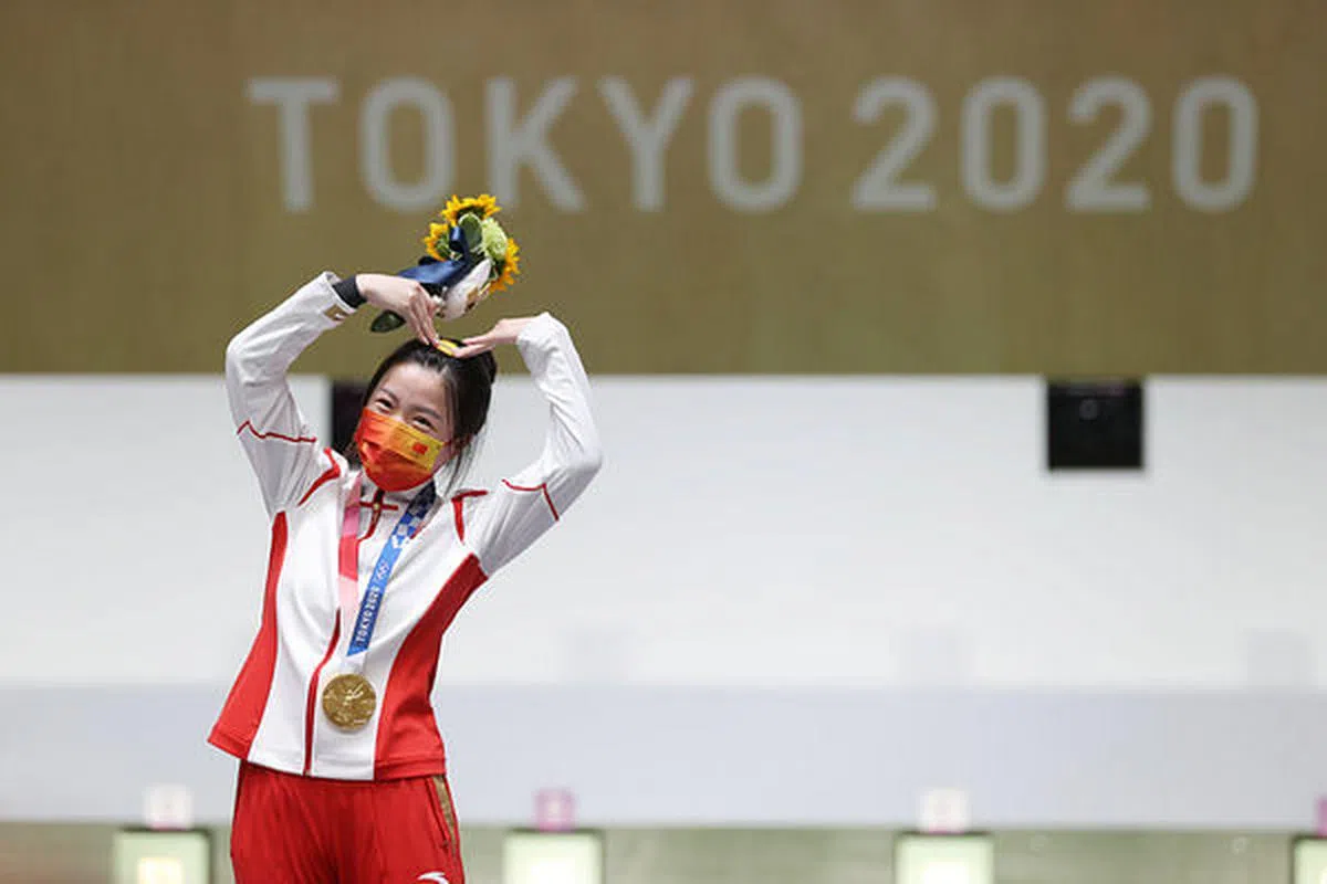 杨倩射下本届奥运首金，在颁奖仪式上对着镜头做出“比心”的动作。（互联网）