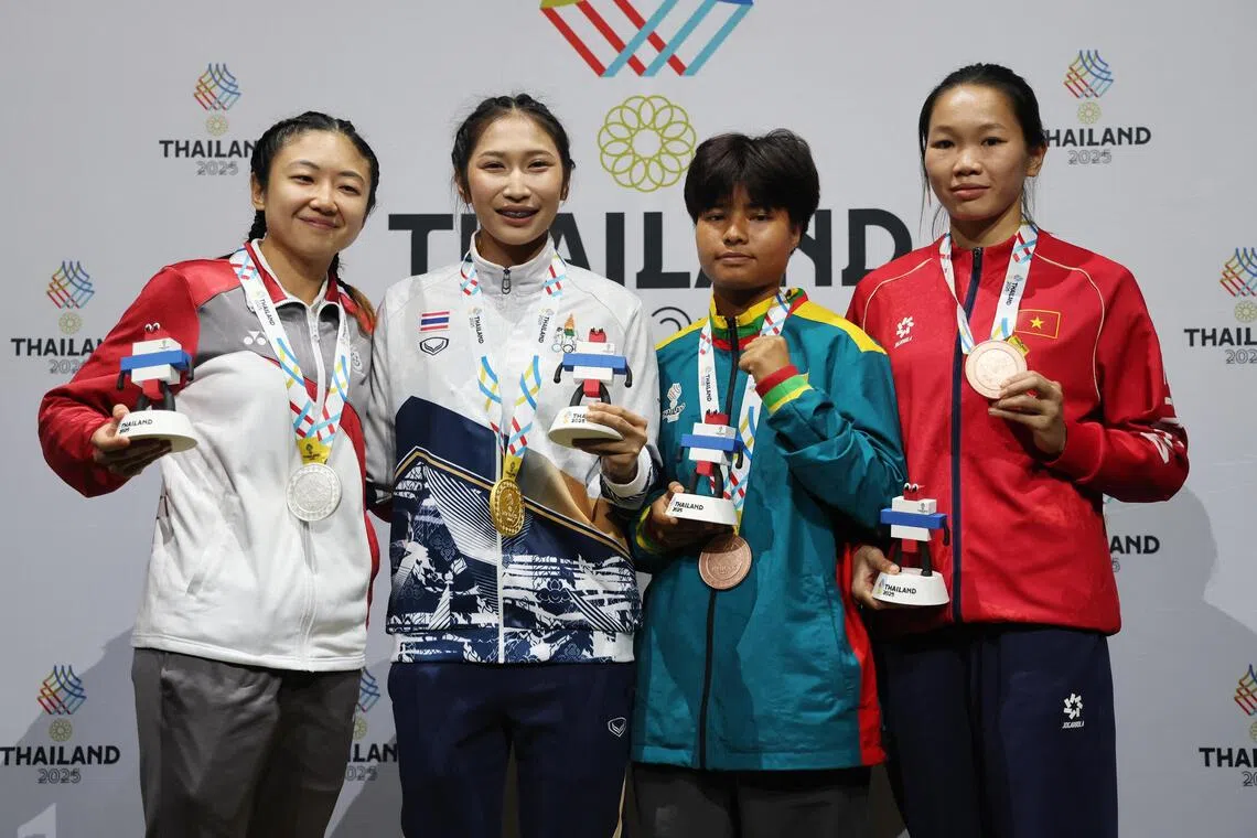 我国女泰拳手张安凌在摘得银牌后，与泰国冠军尼拉婉（左二）、缅甸季军珍来光（译音，右二）和越南季军丁氏花（译音，右一）合影。（路透社）